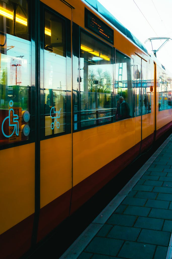 A sleek yellow tram at a station in Baden-Württemberg, Germany, during daytime.