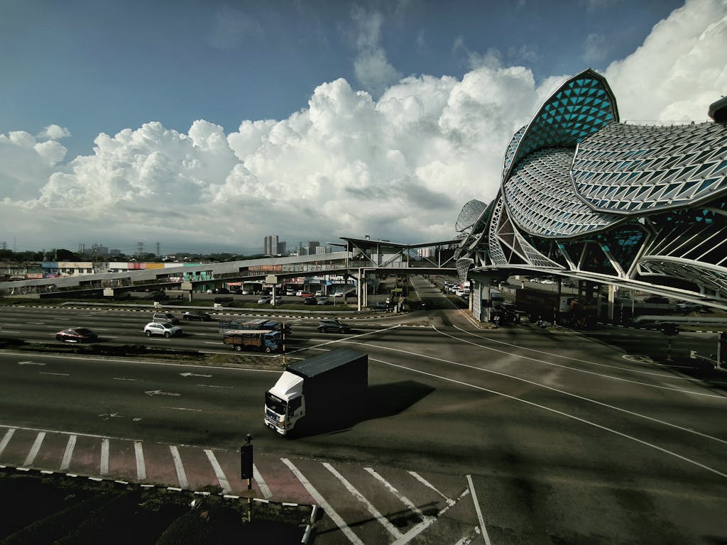 Dynamic view of a highway intersection with modern architectural structure and cloudy sky.