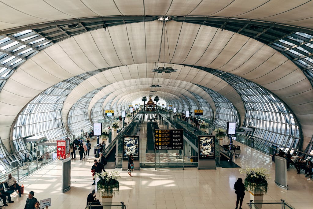 High-angle view of Suvarnabhumi Airport's modern interiors bustling with passengers in Bangkok.